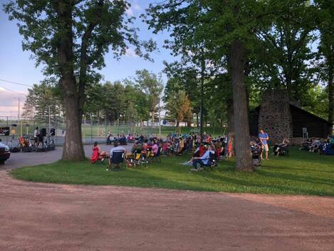 Crowd enjoying live music under the lights at Riverview Park