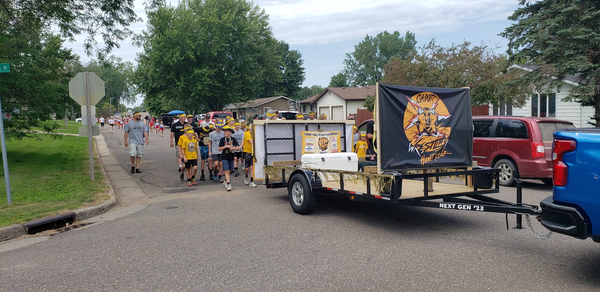 Cadott Wrestling team and supporters marching with their parade trailer