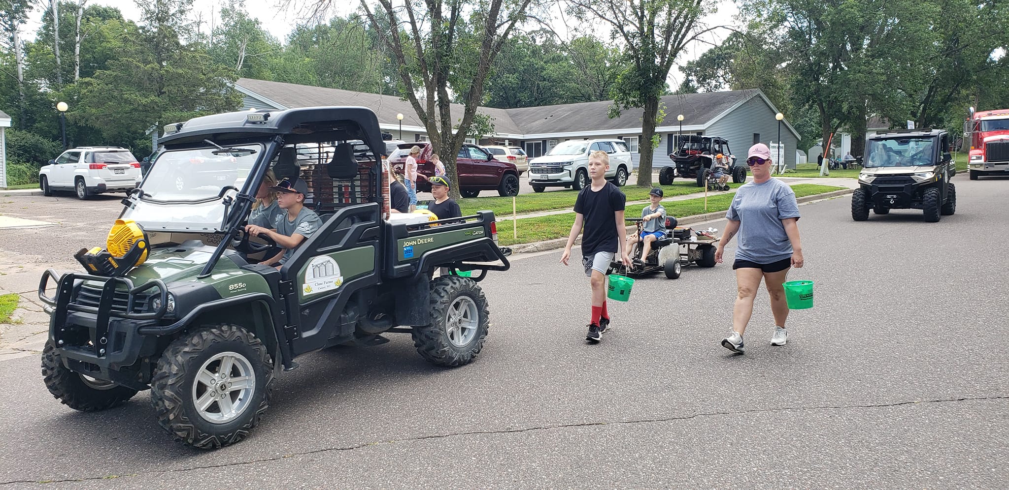 Close Farms parade entry with a green John Deere utility vehicle and family members