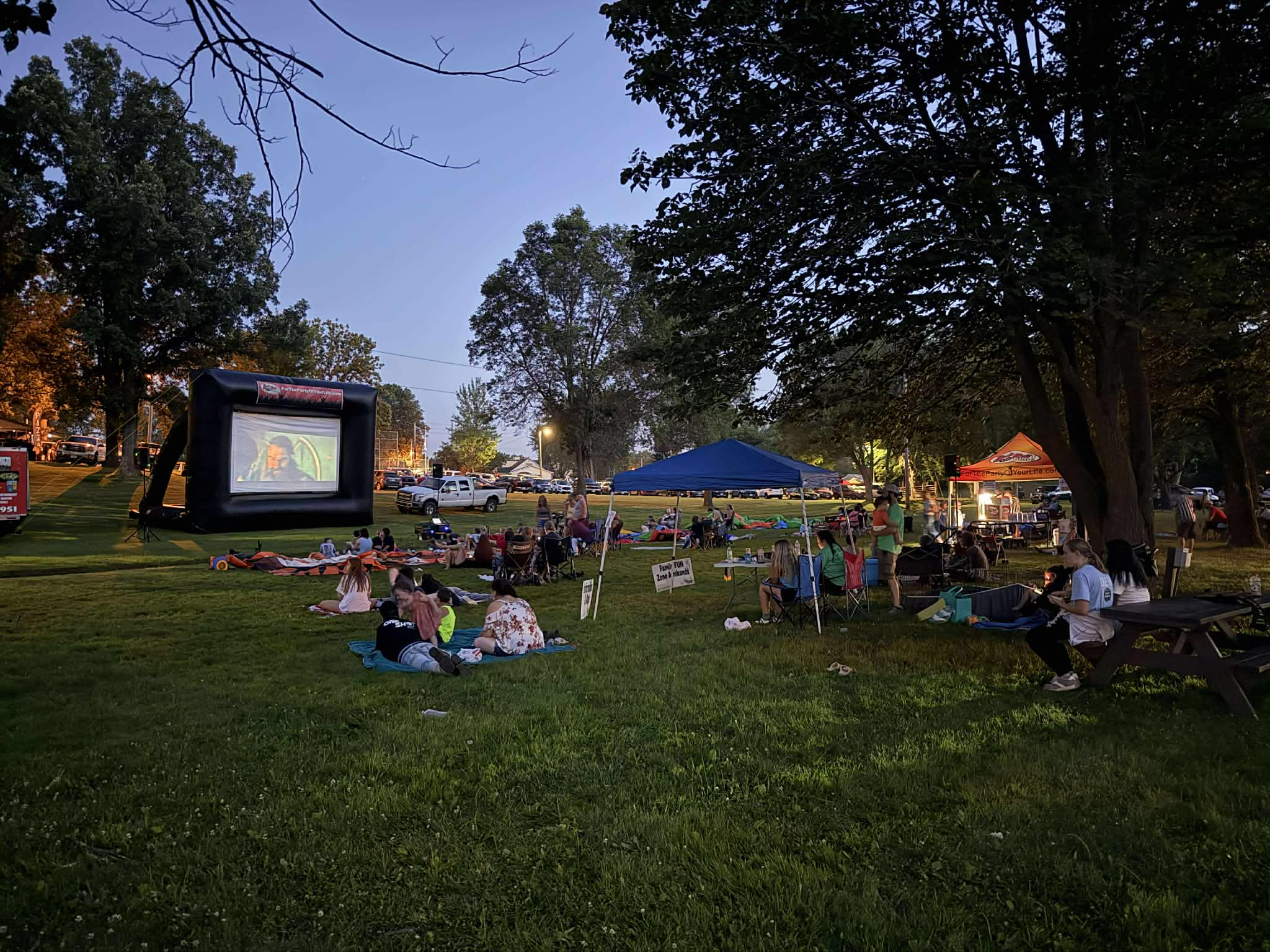 Families watching a movie on an inflatable outdoor screen at Riverview Park