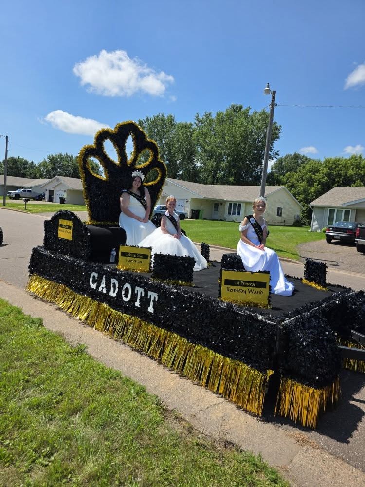 The 2025 Cadott royalty float in black and gold with the Queen and Princesses
