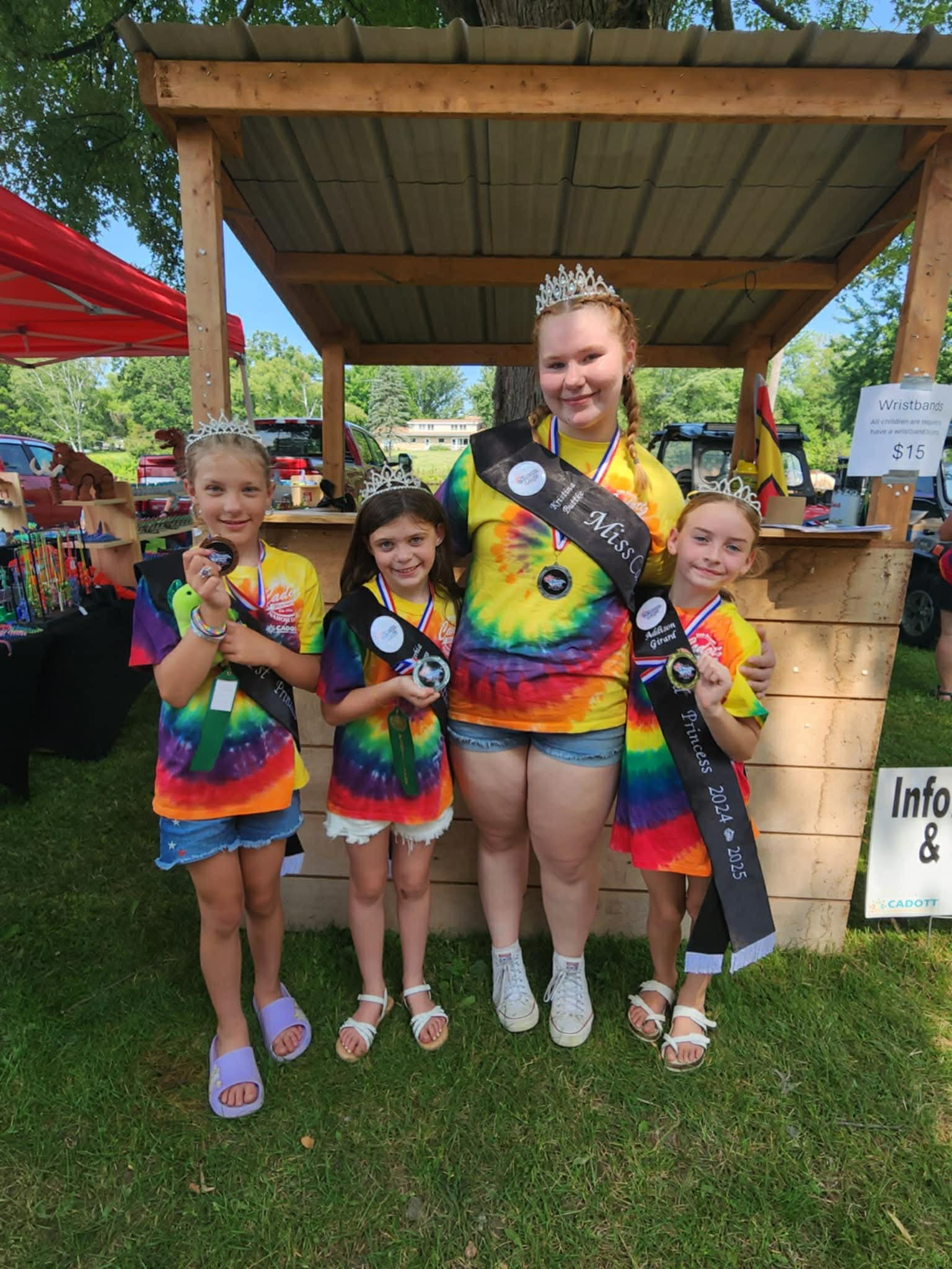 Nabor Days Queen and three Princesses holding medals at the info booth