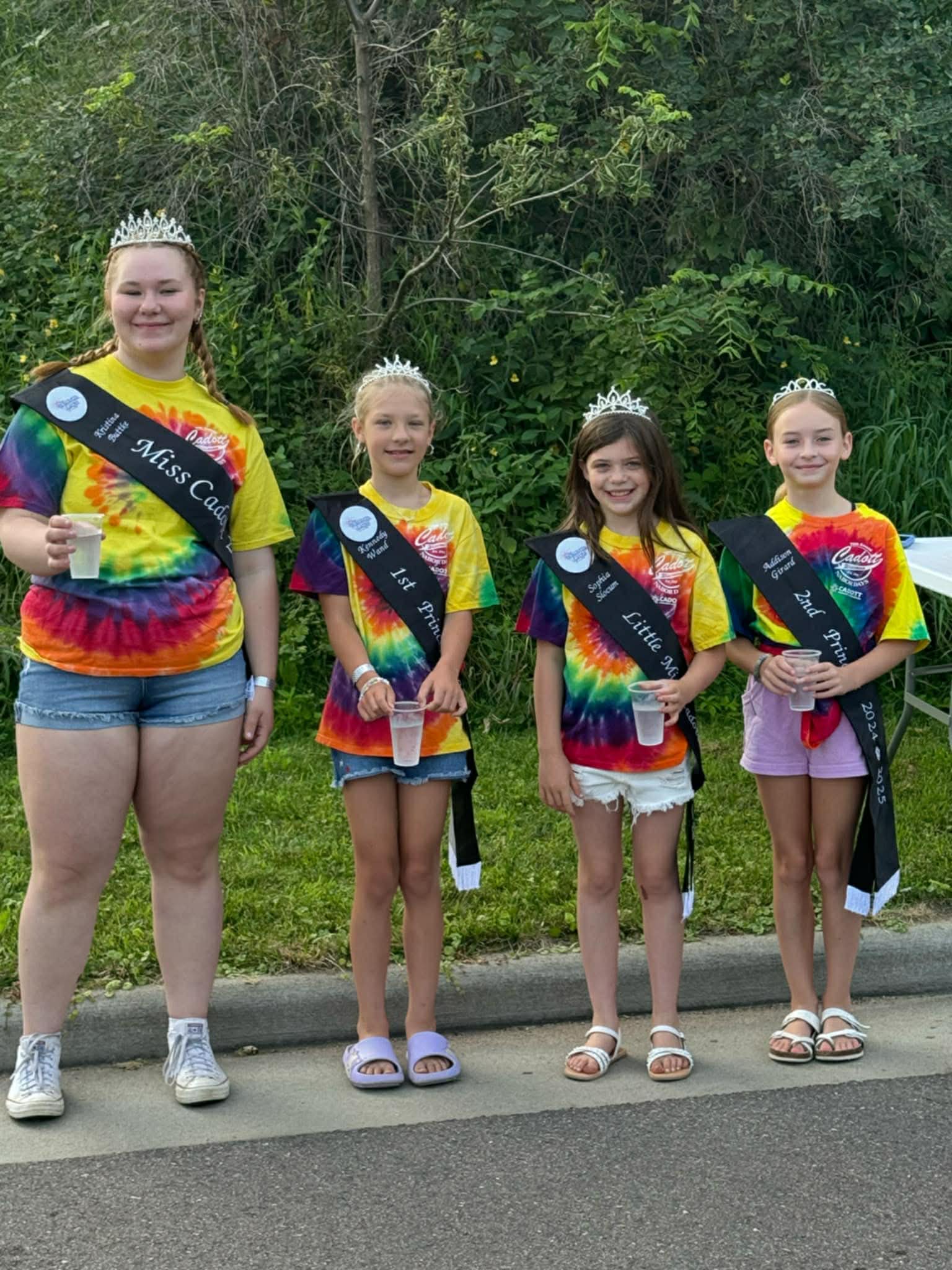2025 Queen and Princesses in tie-dye shirts along the parade route