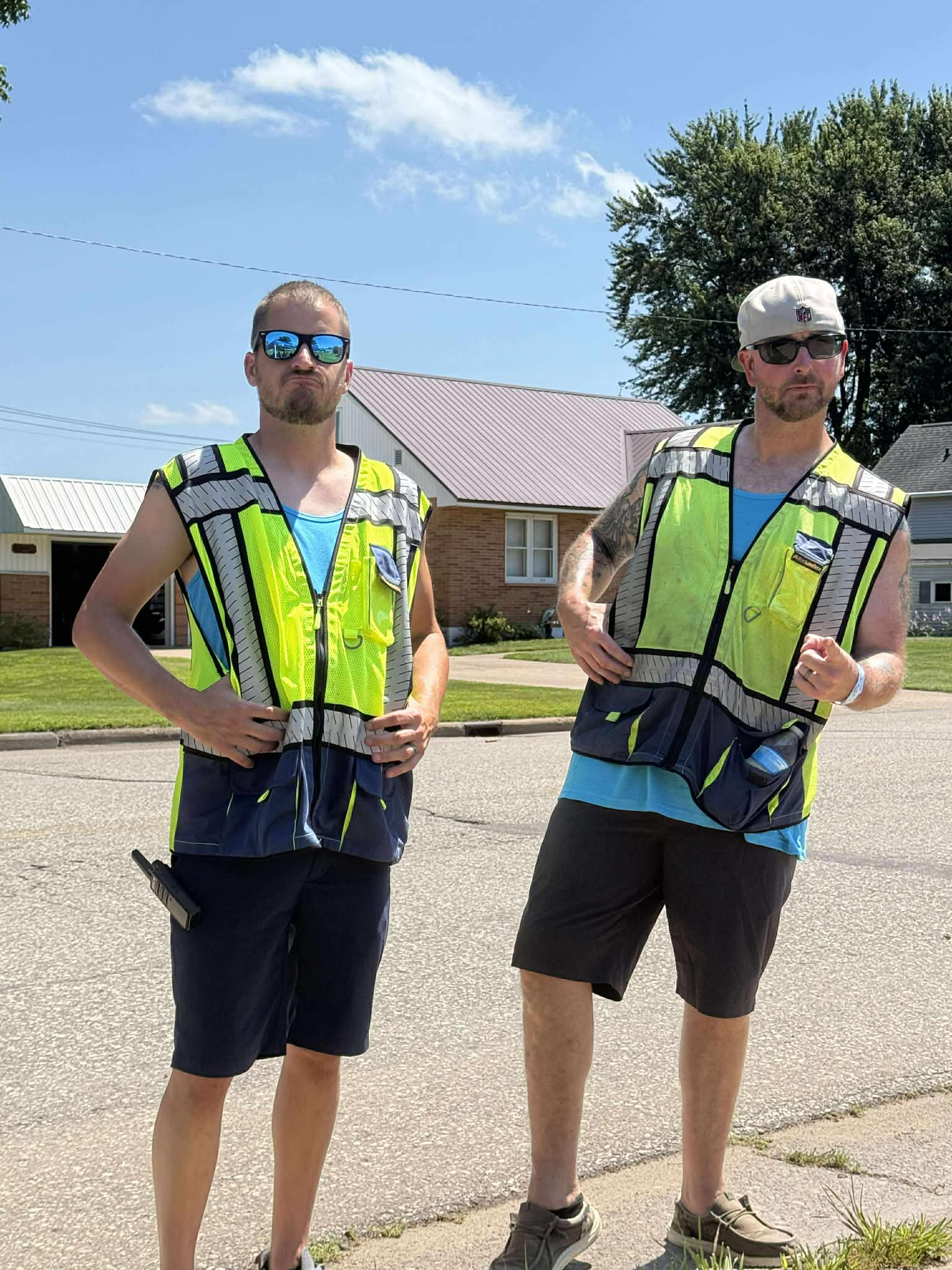Two volunteers in neon safety vests on a Cadott street during Nabor Days