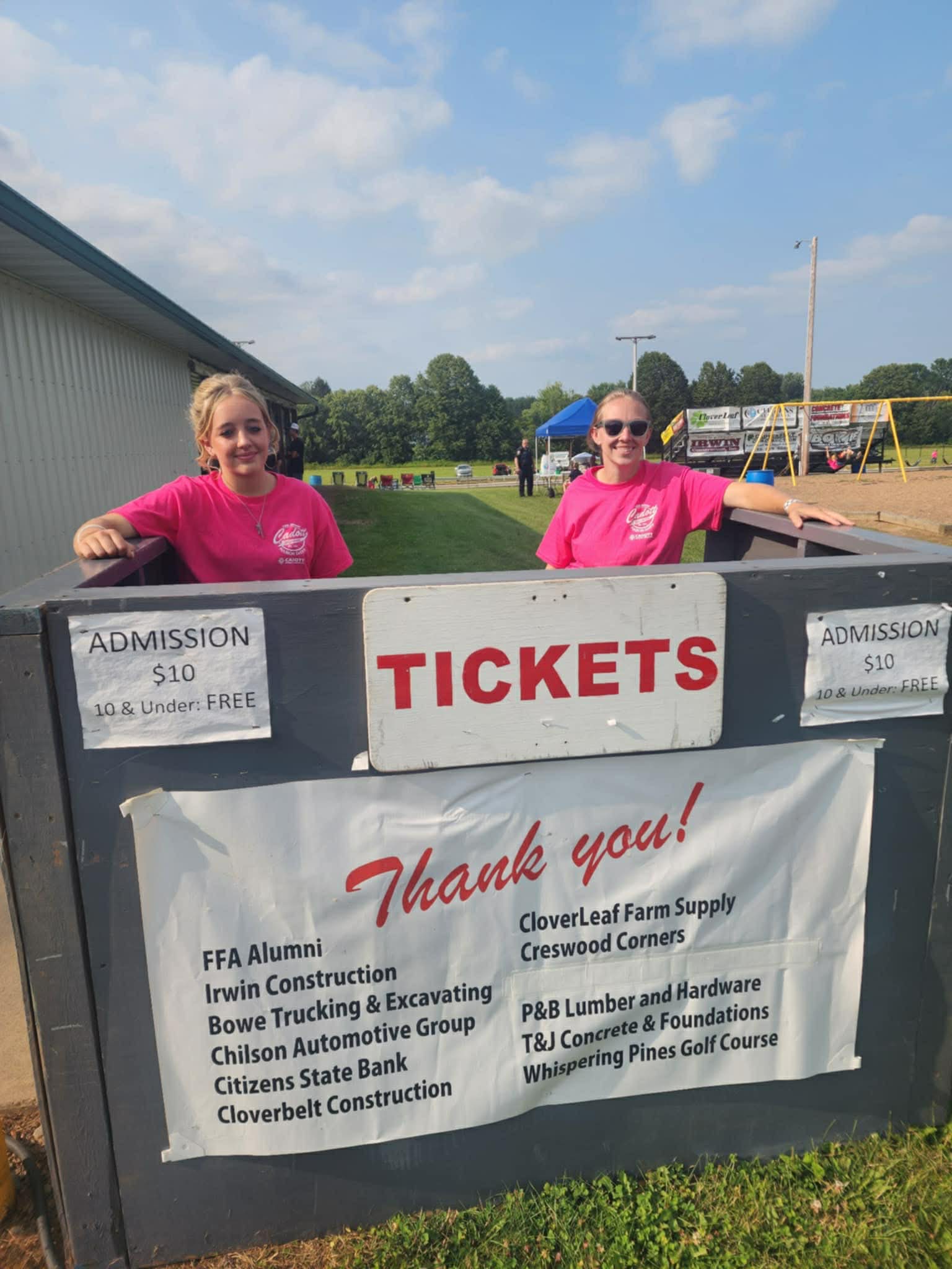 Two volunteers in pink Cadott shirts at the Nabor Days ticket booth