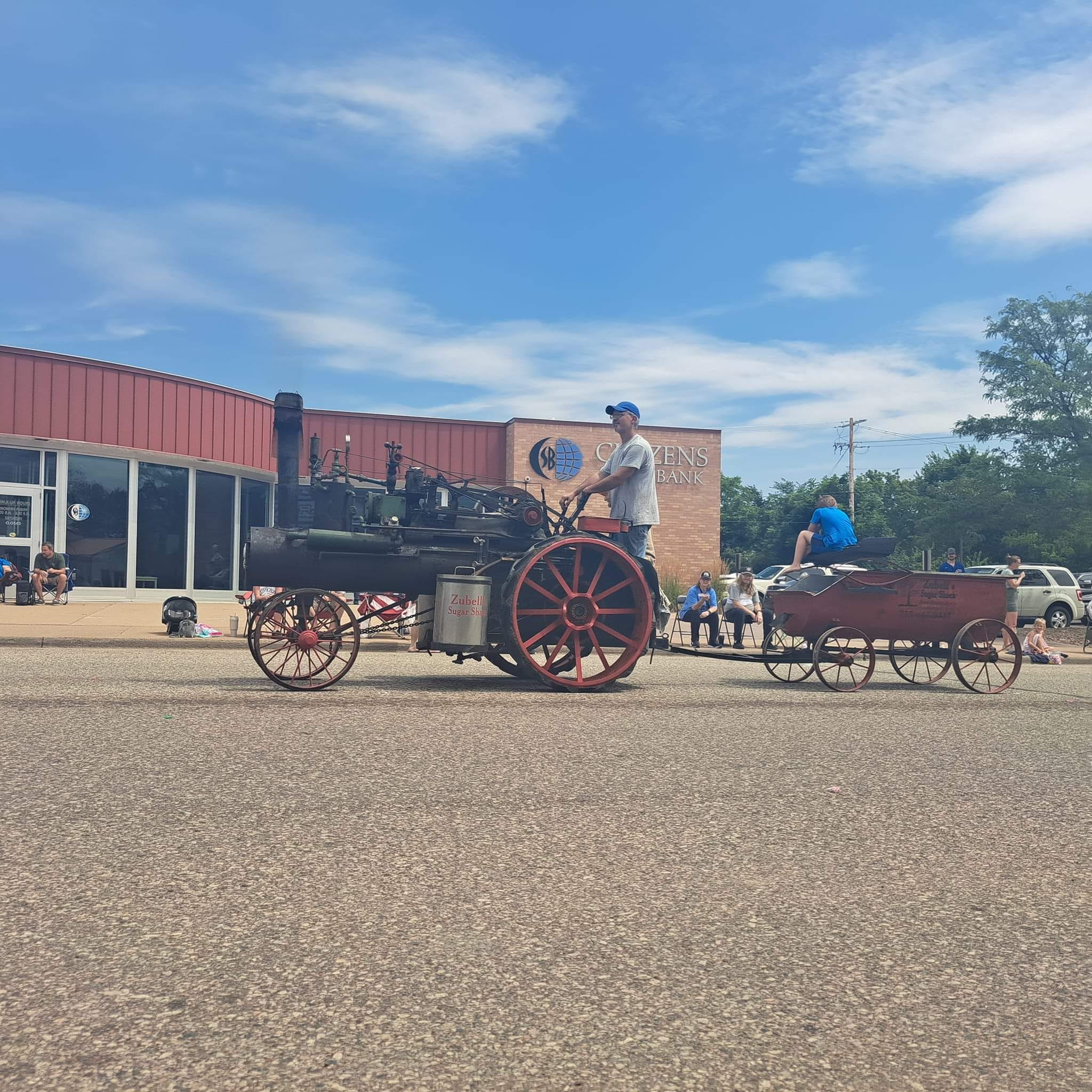 Zubell's Sugar Shack antique steam tractor pulling a wagon through the parade